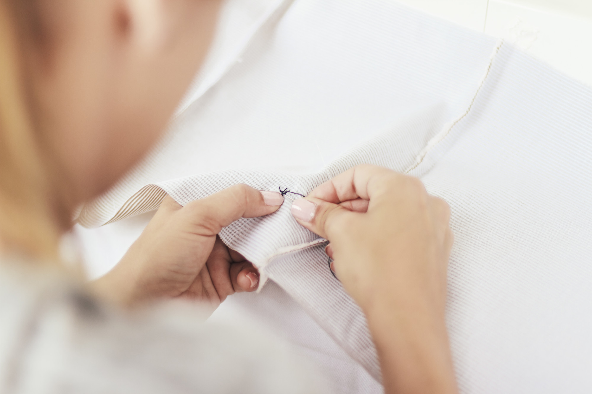 Tutor demonstrating stitch technique on fabric